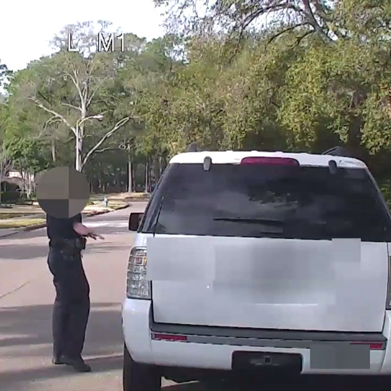 Police officer with face redacted and obscurred stopping vehicle.